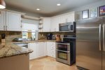 The gourmet kitchen features an electric stove and convection oven